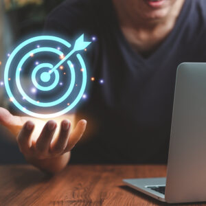 A person holding a laptop and a glowing target.