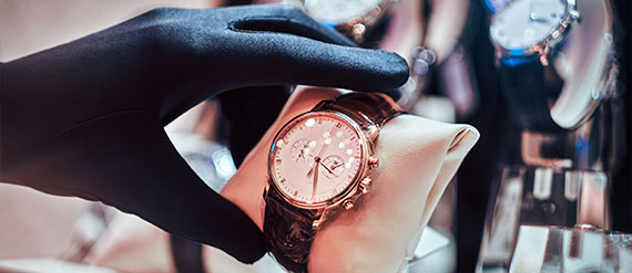 A person wearing gloves holding onto a watch