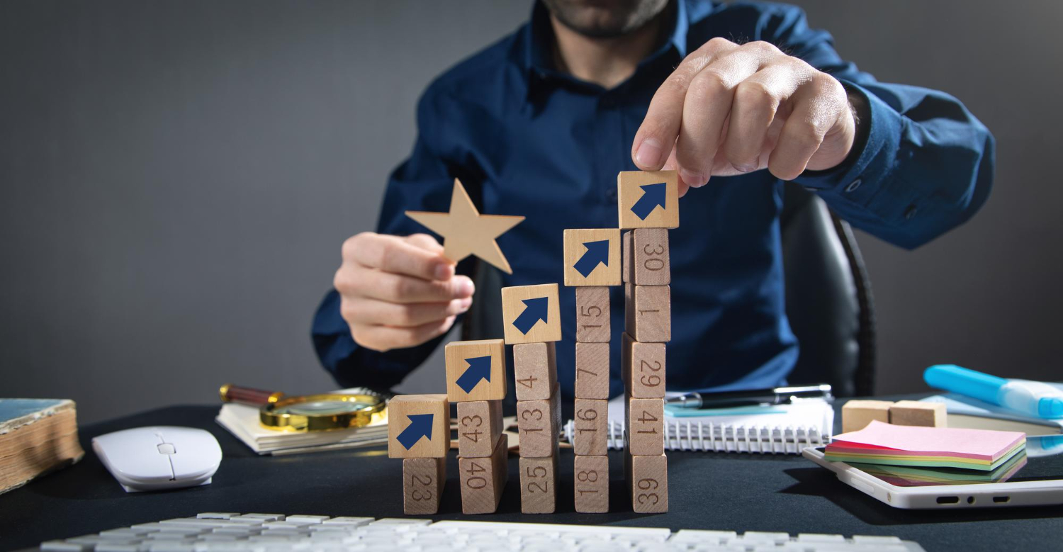 A person building blocks with arrows on them.